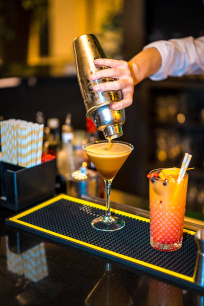 istock Bartender's hand pouring a cocktail on a luxury martini glass 1805386525