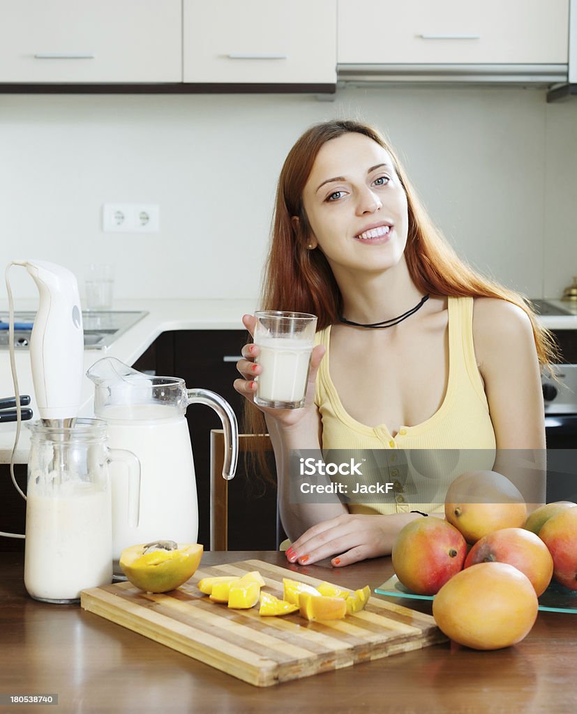 Обычная женщина пить Молочный коктейль с манго - Стоковые фото Блендер роялти-фри