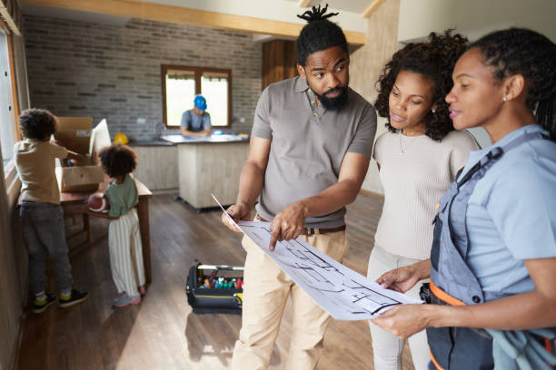 istock Black parents analyzing plans with manual worker inside of renovating home. 1805393458
