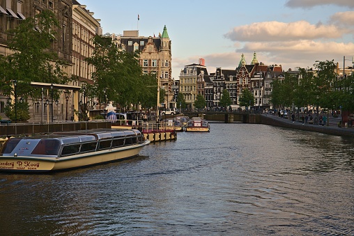 Amsterdam, Netherlands – May 23, 2023: A scenic view of a canal along beautiful buildings in Amsterdam, Netherlands