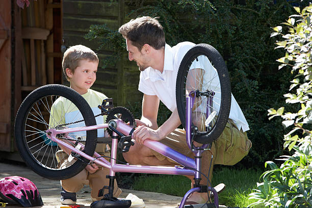 istock Father And Son Mending Bike Together 180540936