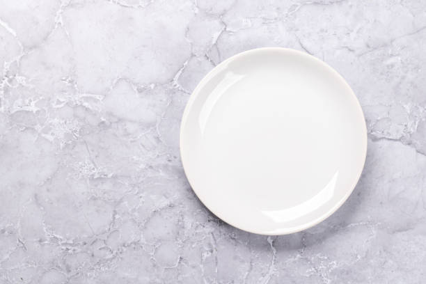 istock Mockup for a delicious meal. Empty plate on a table 1805414947