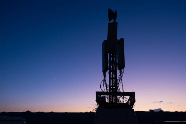Base station tower against a moody dawn sky.