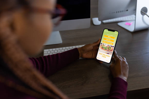 istock Close up of a black office worker using mobile app for food ordering 1805423510