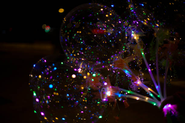 istock Balloons with lights. Garlands in dark. Glowing light bulbs inside empty balls. 1805428651