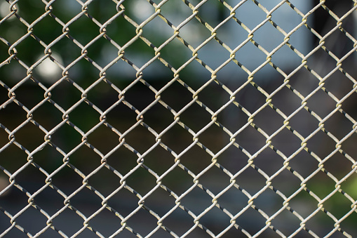 Lattice fence. Steel grating. Steel mesh. Repeating element. Texture of fence.