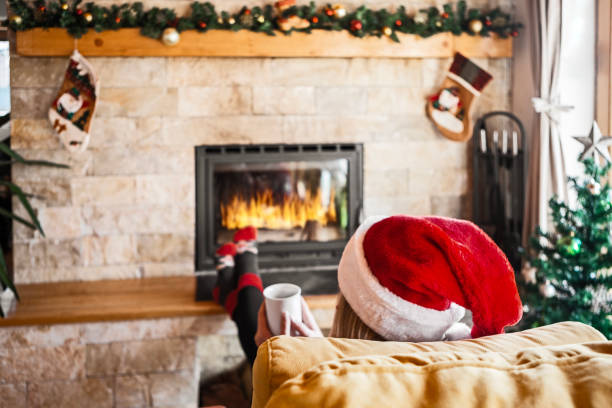 Young woman with Santa hat on Christmas morning enjoying coffee using smart phone