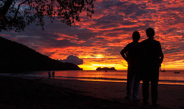 Gorgeous Sunset Mother and daughter view a sunset at Playa Hermosa, in the Guanacaste province of Costa Rica. costa rican sunset stock pictures, royalty-free photos & images