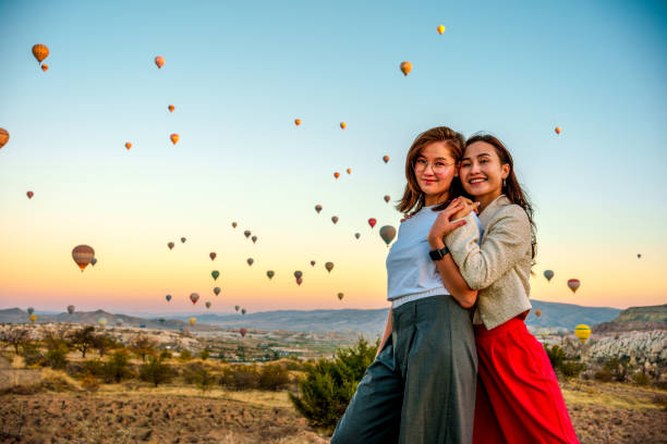 turystki, które lubią oglądać balony latające po niebie podczas wakacji, cieszą się wakacjami i widokami, tańcząc i bawiąc się ze sobą - mountain mountain peak snow spring zdjęcia i obrazy z banku zdjęć