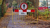 Reckless Pedestrian Walking Past Street Roadworks Safety Barrier with Pedestrians Forbidden Closed Walkway Sign