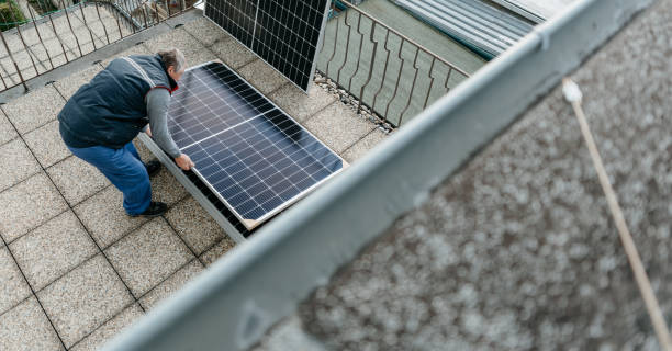 hombre instalando un sistema de paneles solares fotovoltaicos en una casa familiar. concepto de energía alternativa - procession panel fotografías e imágenes de stock