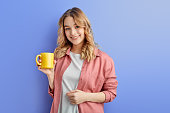 cute positive girl drinking coffee or tea in morning before school or university