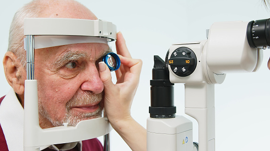 An ophthalmologist checks the vision of an elderly person using modern equipment. The concept of advertising ophthalmological services and medical technologies.