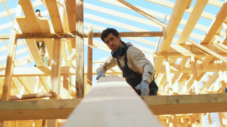 man in uniform and headphones carrying board at construction site