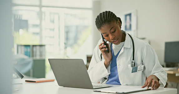 Woman, doctor and phone call with results in hospital, clinic or medical office with document, report or clipboard. Black person, healthcare and laptop for remote consultation of medicare information