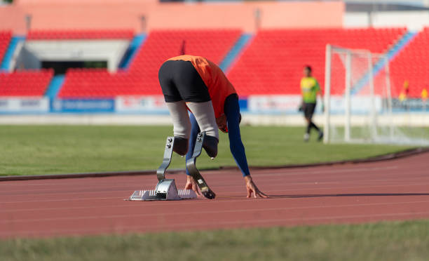 istock Disabled athletes prepare in starting position ready to run on stadium track 1805514816