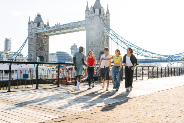 ロンドンで結ばれた幸せな若い友人の多民族グループ - travel teenager talking student ストックフォトと画像