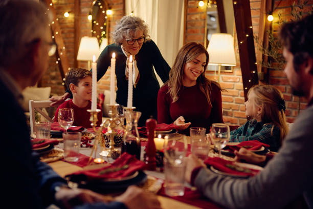 istock Happy extended family talking during Christmas dinner at dining table. 1805517635