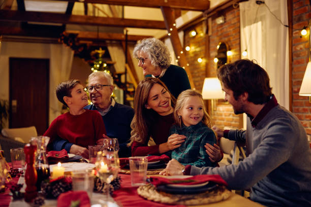istock Happy multigeneration family communicating while gathering at dining table on Christmas Eve. 1805517643