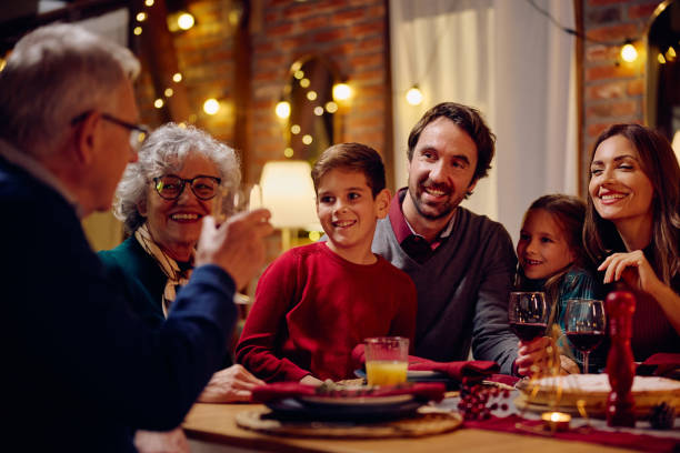 istock Happy extended family talking while having meal at dining table on Christmas Eve. 1805518173