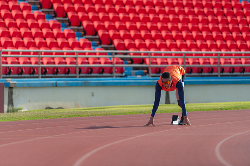 Disabled athletes prepare in starting position ready to run on stadium track