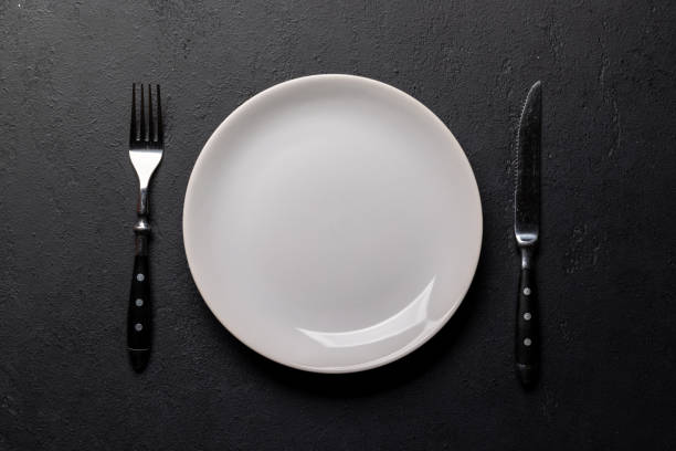 istock Mockup for a delicious meal. Empty plate on a table 1805521156