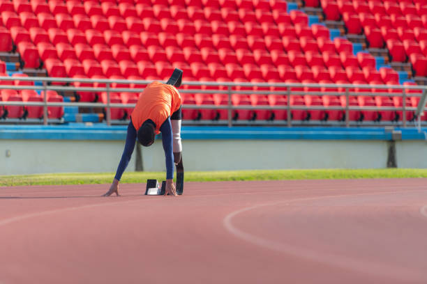 Runner legs on red running track in stadium