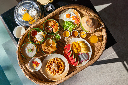 Top view Photo of a set of Phuket Local Delights Breakfast Set in a Floating Basket by a Swimming Pool