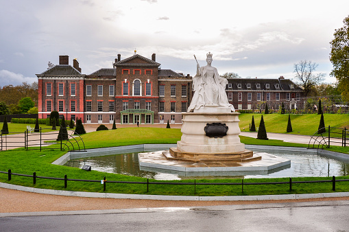 London, UK - April 2018: Kensington palace and Queen Victoria monument in London