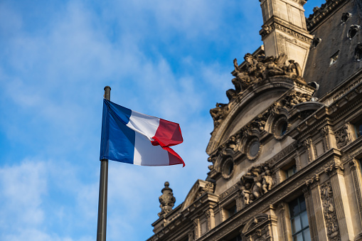 French flag in front of a historical building