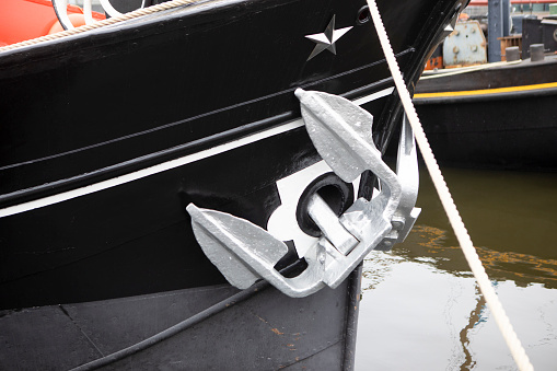 Boat cleaning equipment. Plastic bucket, hose with water spray gun, mop laying on the yacht. Close up. Yacht maintenance concept.