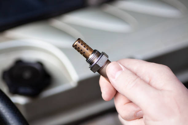 istock Oxygen sensor for gasoline and diesel engines in the hand against car engine. Mechanic holds oxygen sensor. lambda probe 1805582103