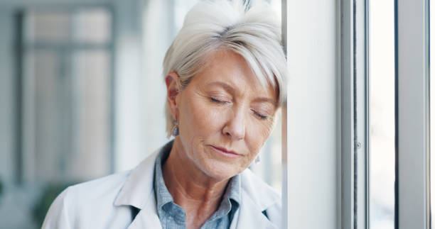 burnout, dor de cabeça e cansaço médico sênior no hospital com vertigem, ansiedade ou problema de névoa cerebral. saúde, falha e idosa cirurgiã exausta, depressão ou saúde mental, fadiga - senior women defeat headache frustration - fotografias e filmes do acervo