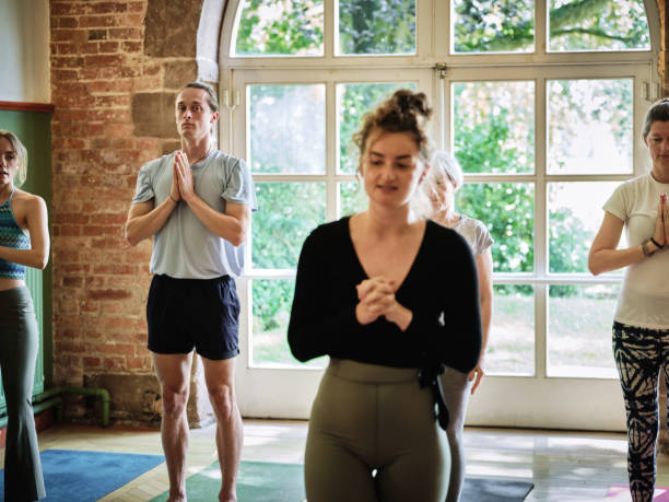 istock Meditation, breathing and instructor with people in yoga class, exercise and holistic practice. Spiritual, mindfulness and teacher training group to workout with peace, zen and meditate on chakra 1805636262