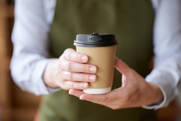 istock Hand of a cafe clerk offering coffee 1805637435