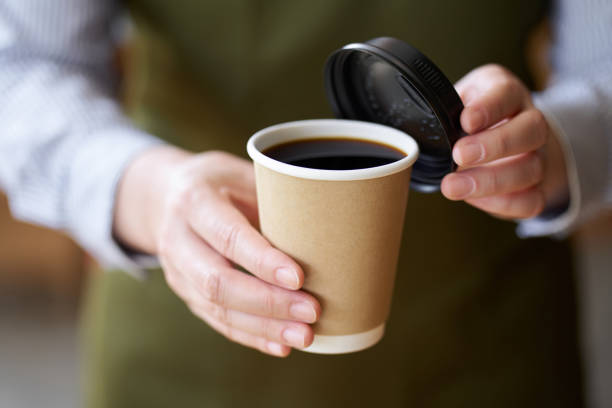 Hand of a cafe clerk offering coffee