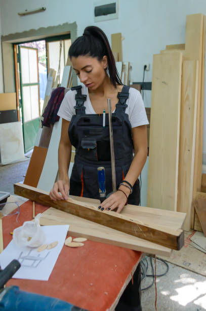 istock Female Carpentry Worker is Preparing a Wooden Plank for Woodwork. 1805637962
