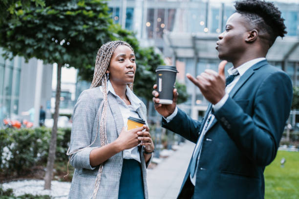 istock Two young blakc people drinking coffee near office 1805642397