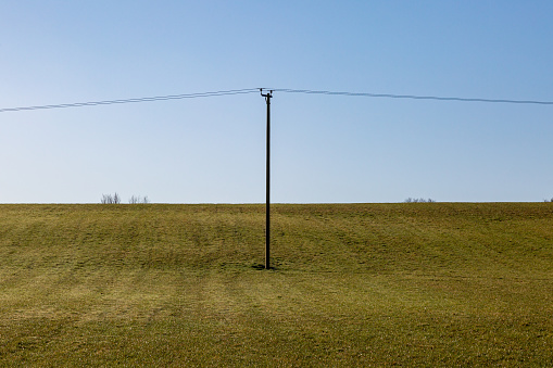 A field in Sussex with a telegraph pole, on a sunny winter morning
