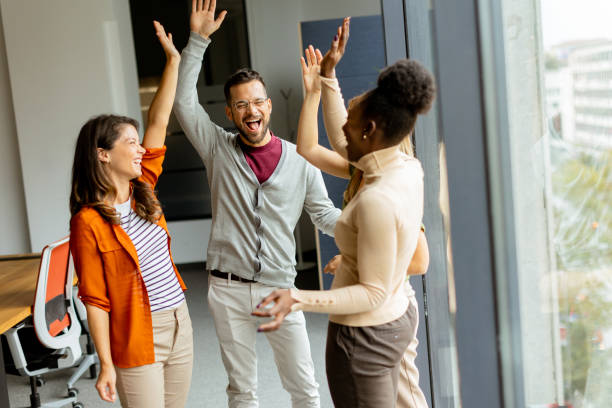 istock Young multiethnic startup team hold hands together in the modern office 1805658331