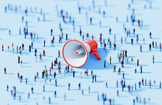 Human crowd surrounding red megaphone object on blue background. Horizontal  composition with copy space.