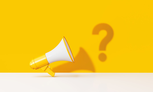 Question mark and yellow megaphone over yellow background. Horizontal composition with copy space. Great use for announcement concepts.