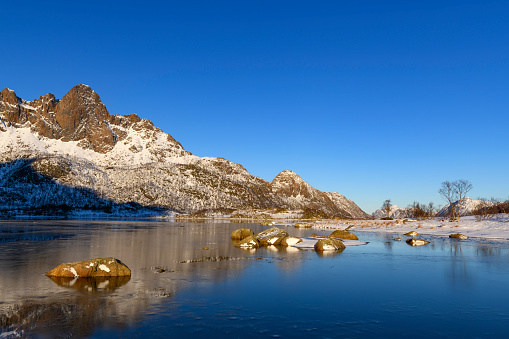 Winter landscape with mountains and Lake Baikal in Siberia on sunny day. Natural background with copy space.