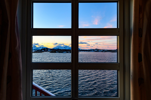 View outside a window on the cold winter fjord at Vesterålen archipelago in Northern Norway during a beautiful sunny morning.