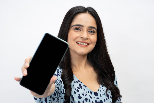 Photo of young girl showing device screen on white background