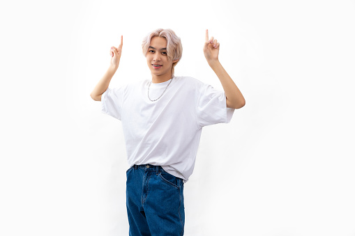 blank template t shirt. asian man with white t shirt and pointing hand up. Fashion portrait Asian young man. model, clothing and cosmetics. Young male model blond hair isolated on white background