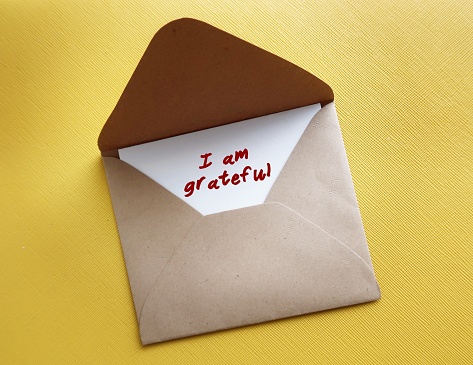 Card in envelope with handwriteen text I AM GRATEFUL - concept of gratitude , means being thankful or show appreciation for good things or kindness in life