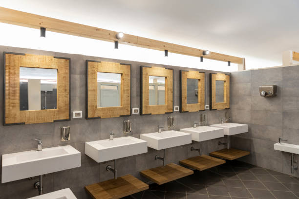 istock Public bathroom with five sinks, mirrors and soap dispensers. Modern and simple 1805709509