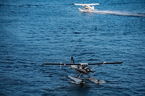 Vancouver, Canada – February 09, 2022: Aerial view of three seaplanes on a tranquil ocean in Vancouver, Canada