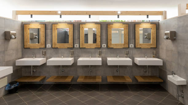 istock Public bathroom with five sinks, mirrors and soap dispensers. Modern and simple. 1805716819